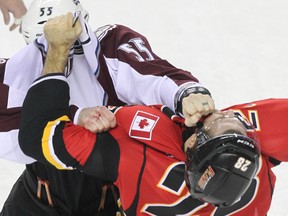 Colorado Avalanche's Cody McLeod and Calgary Flames' Lane MacDermid fight during NHL hockey action at the Saddledome in Calgary on December 6, 2013. (Jim Wells/Calgary Sun/QMI Agency)