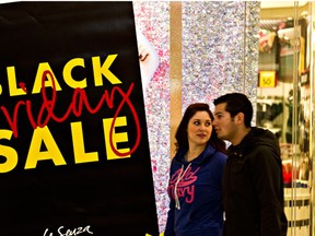 Shoppers at Southgate Centre walk past a Black Friday sale sign in Edmonton, Alta., on Friday, Nov. 29, 2013. Codie McLachlan/QMI Agency