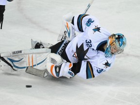 Goalie Alex Stalock from the San Jose Sharks has a moment as he tries to clear the puck against the Calgary Flames in NHL hockey action at the Saddledome in Calgary on March 24, 2014. (Stuart Dryden/Calgary Sun/QMI Agency)