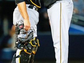 According to Mark DeRosa, now of MLB Network, Russell Martin (left) played a key role in helping Edinson Volquez (right) post a career-best 3.04 ERA for the Pirates this past season. (AFP)