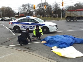 Ottawa Police investigate the scene of a fatal accident Thursday. The cyclist was struck and killed by a truck at Lotta Ave. (ERROL McGIHON Ottawa Sun)