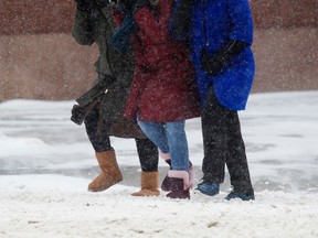 Pedestrians make their way through the blowing snow along Jasper Avenue near 102 Street, in Edmonton Alta., on Thursday Nov. 27, 2014. David Bloom/Edmonton Sun