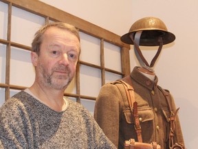 Woodworker Tim Soper sits next to one of his Canadian army uniforms from the First World War. He is trying to equip members of the Princess of Wales Own Regiment with several of the uniforms for a march they will make next May to re-enact the departure of the 21st Battalion to fight in the war. (Michael Lea/The Whig-Standard)