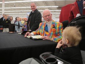 Hockey commentator Don Cherry says hello to Grace George, 2, at Walmart during a book signing Thursday night. (Elliot Ferguson/The Whig-Standard)