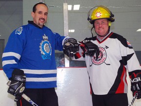 St. Thomas police Const. Jeff DeLeeuw, left, bumps elbows with St. Thomas firefighter Daryl Smith on the ice at the Timken Centre in St. Thomas. City police and firefighters are taking part in the inaugural Heroes for Hope Guns and Hoses charity hockey game Saturday, with proceeds to prostate cancer research.

Ben Forrest/Times-Journal