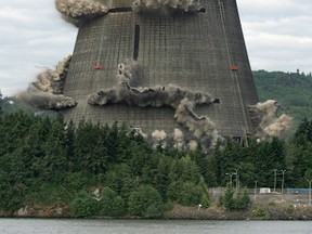The 499-foot cooling tower at the Trojan Nuclear Plant in Rainier, Oregon is imploded May 21, 2006.  Portland General Electric's facility located 42 miles North of Portland on the Columbia River is the first large-scale commercial nuclear plant to be decommissioned in the United States.  The implosion of the 41,000 tons of concrete and steel took only 10 seconds and 2,800 pounds of dynamite.  The tower provided water cooling for electricity production in the region from 1976-1993.