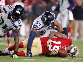 San Francisco 49ers wide receiver Michael Crabtree suffers an injury after being tackled by Seattle Seahawks strong safety Kam Chancellor and middle linebacker Bobby Wagner in the first quarter at Levi's Stadium on Nov. 27, 2014. (Cary Edmondson/USA TODAY Sports)