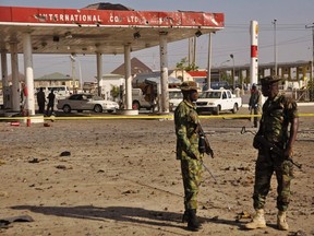 Members of the military stand at the scene of an explosion near a petrol station in Kano in this November 15, 2014 file photo. (REUTERS/Stringer)