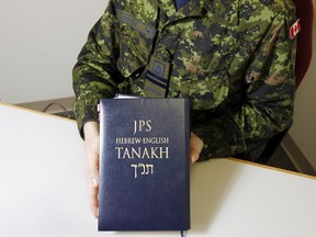 JEROME LESSARD/THE INTELLIGENCER
Capt. Bryan Bowley, the first and only rabbi with the Royal Canadian Air Force (RCAF), holds his copy of the Tanakh, or the Jewish Bible, in his Yukon Street office at 8 Wing/CFB Trenton Thursday. Bowley asked not to have his face photographed.