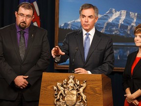 Premier Jim Prentice (centre) speaks beside Ian Donovan (left) and Kerry Towle during a press conference at the Alberta Legislature announcing two new Progressive Conservative MLAs, Towle and Donovan, who crossed the floor of the Alberta Legislature from the Wildrose Party in Edmonton, Alta., on Monday, Nov. 24, 2014. Ian Kucerak/Edmonton Sun/ QMI Agency