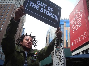 A protester demonstrates outside Macy's store while chanting "Hands up, don't shop" in support of the late Michael Brown on the traditionally busy Black Friday shopping day in New York November 28, 2014. (REUTERS/Carlo Allegri)