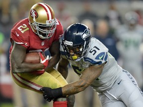 Seahawks linebacker Bruce Irvin (right) tackles 49ers running back Frank Gore (left) during NFL action in Santa Clara, Calif., on Thursday, Nov. 27, 2014. (Kirby Lee/USA TODAY Sports)