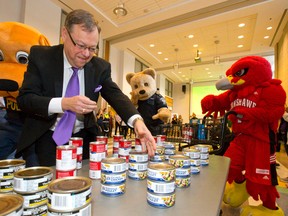 Business Cares campaign chairperson Wayne Dunn gets help from London Police mascot Caesar, left, Middlesex-London EMS mascot Perry the Bearamedic and Fanshawe College mascot Freddie the Falcon as they gather food items while competing against other teams to fill their shopping cart at the kickoff Friday for the Business Cares Food Drive at Western University?s London Hall. (CRAIG GLOVER, The London Free Press)