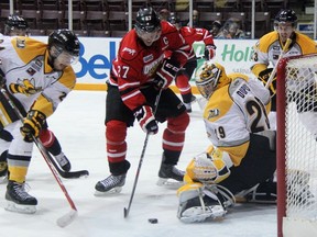 Owen Sound Attack captain Zach Nastasiuk is stopped by Sarnia Sting goalie Taylor Dupuis during OHL action Friday night in Sarnia. Sting defenceman Kevin Spinozzi watches the play unfold. (TERRY BRIDGE, The Observer)