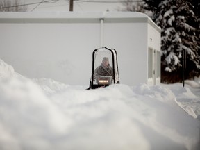 A worker clears snow from a sidewalk on November 28, 2014 in downtown Whitecourt, Alta. In less than 24-hours, 43 cm of snow fell breaking previous historical records for most snowfall in a day (previously 5.2 cm, recorded in 2001) and most snow accumulation by this date (previously 30.6 cm, recorded in 1996, according to Environment Canada's records starting in 1978. Adam Dietrich | Whitecourt Star