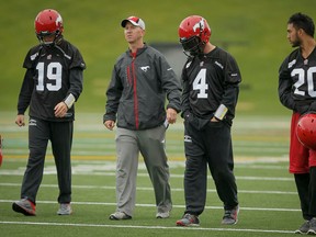 Offensive coordinator Dave Dickenson walks with quarterbacks (L-R) Bo Levi Mitchell, Drew Tate and Bryant Moniz after a Calgary Stampeders practice in Calgary, Alta., on Friday, June 13, 2014. (Lyle Aspinall/QMI Agency)