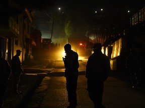 Afghan policemen stand guard at the site of a suicide attack at the foreign guesthouse in Kabul on November 27, 2014. AFP PHOTO/SHAH Marai