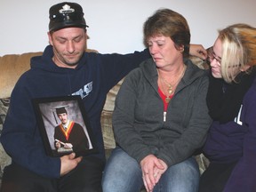 The family of Ryan Pearce, a 19-year-old construction worker killed in a house collapse in September, is still waiting for answers. A heartbroken Colleen Pearce is seen here gazing at her son's high school graduation photo while being comforted by her husband Martin Rochaleau (Ryan's stepdad) and Ryan's longtime girlfriend Tiffany Winship. CHRIS DOUCETTE/TORONTO SUN