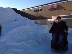 Zachary Weeks, 26, poses in front of a pile of snow blocking access to handicap parking at West Edmonton Mall in Edmonton, AB on Saturday, November 29, 2014. Photo Supplied/Twitter