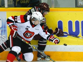 Ottawa 67's' Connor Graham fights for the puck along the boards against  Peterborough Petes' Stephen Nosad during first period OHL action on Saturday, Nov. 29, 2014, at the Memorial Centre in Peterborough. (Clifford Skarstedt/Peterborough Examiner/QMI Agency)