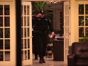A Toronto Police officer exits an apartment building on Thorncliffe Park Blvd. where three people were found dead on Nov. 29, 2014. (John Hanley/Special to the Toronto Sun)