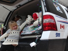 Kennedy Armer, 7, places a toy into a London police vehicle parked inside White Oaks Mall on Saturday. The annual toy drive supports LifeSpin?s Christmas family-sponsorship program. (DALE CARRUTHERS/THE LONDON FREE PRESS)