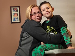 Debra Warren hugs her son Leland at their home in Ottawa. Debra says her son isn't receiving the support he needs from the public school board. (Tony Caldwell/Ottawa Sun)