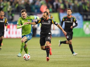 Seattle Sounders FC midfielder Brad Evans (3) and Los Angeles Galaxy forward Landon Donovan (10) chase the ball in the second half during the Western Conference Championship at CenturyLink Field on Nov 30, 2014 in Seattle, WA, USA. (Steven Bisig/USA TODAY Sports)