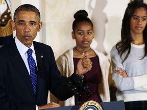 U.S. President Barack Obama delivers remarks, along with daughters Sasha and Malia (R),before  pardoning the National Thanksgiving turkey at the White House in Washington November 26, 2014. REUTERS/Gary Cameron