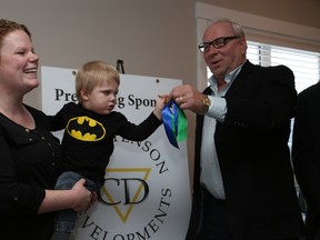 Twenty-one-month-old Gage Trymchy can’t wait to get the keys to the house he’ll share with his mom Landon See from Christenson Developments’ Peter Dirksen.