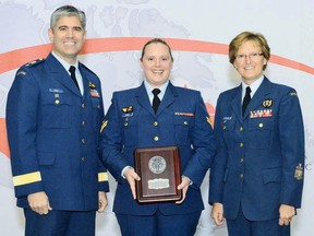 Soccer coach Mast. Cpl. Maria Toone, centre, is presented with the award by former commanding officer of the Trenton air base, Brig. Gen. Sean Friday, left, and Chief Warrant Officer Dianne Maidment, during the 26th Canadian Armed Forces Sports Awards Ceremony in Ottawa earlier this fall. — Photo by Cpl. Heather Tiffney