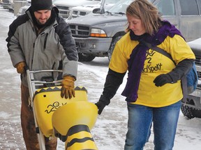 Lee Markert, a member of the Vulcan County Kidsport Committee, gets some help from Colleen Carey, committee chair, in moving the “Toilet Challenge” bowl from the Co-operators down to Shearer Agencies Friday afternoon, when temperatures dipped as low as about -20C, with the windchill making it feel even colder. The challenge is part of an effort to raise awareness and funds for KidSport, which helps disadvantaged children get involved in sports.  
Simon Ducatel Vulcan Advocate