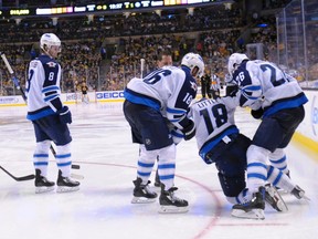 Winnipeg Jets center Bryan Little (18) is helped up by teammates left wing Andrew Ladd (16) and right wing Blake Wheeler (26) during the third period against the Boston Bruins on Friday. The Jets say the injury isn't serious. (Bob DeChiara-USA TODAY Sports)