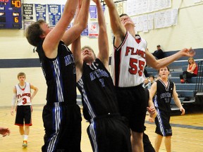 Josh Taylor (left) and Brady Wietersen of the MDHS senior boys basketball team leap high for a piece of this rebound during the championship game of the Mitchell Bowl basketball tournament last Saturday against Kitchener Rockway. ANDY BADER/MITCHELL ADVOCATE