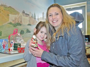 Lilly Ruston (left), and her mom Lee-ann hold up a Christmas gift they picked out for a family member, during the Children's Christmas Shopping Extravaganza and Book Sale on Saturday, Nov. 22 at Thamesview United Church in Fullarton. KRISTINE JEAN/MITCHELL ADVOCATE