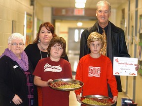 Noelle's Gift Foundation members Jackie Major-Daamen and Kevin Cannon present a $7,800 donation to Elaine Lewis of the Chatham-Kent Student Nutrition Program, far left. Holy Family Catholic students Keegan Devine and Dakota Gough in Wallaceburg show off some of the food that the school enjoys. (DAVID GOUGH, QMI Agency)