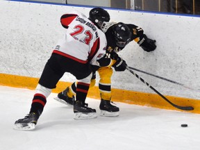 Jared Sykes (11) of the Mitchell Midgets battles for the puck against the end boards with Goderich's Jared Cox (23) during WOAA regular season action Nov. 28. Mitchell won, 6-4. ANDY BADER/MITCHELL ADVOCATE