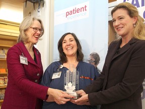 Leslee Thompson, left, president and CEO of Kingston General Hospital, and ER nurse Angela Arnold, centre, accept the Canada's Passion Capitalist award from Leslie Carter during a ceremony Monday at KGH. (Michael Lea/The Whig-Standard)