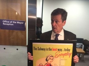 Mayor John Tory shows the subway poster that Rob Ford left in the mayor's office for him on his first day Monday December 1, 2014. (Don Peat/Toronto Sun)