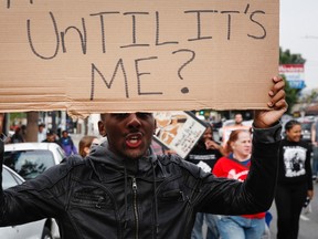A demonstrator holds a placard reading "How long until it's me?" during a rally against the Missouri grand jury's decision to not indict Darren Wilson for his fatal shooting of Michael Brown and the LAPD's fatal shooting of Ezell Ford, outside the LAPD's Newton Division police station in Los Angeles, California December 1, 2014. Ezell Ford, 25, was killed by police in Los Angeles on August 11, 2014, two days after Michael Brown, 18, was shot dead by Darren Wilson, who has since resigned as a police officer, in St. Louis. U.S. President Barack Obama asked Congress on Monday for $263 million for the federal response to the civil rights upheaval in Ferguson, Missouri, and is setting up a task force to study how to improve modern-day policing. REUTERS/Patrick T. Fallon