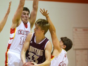 Banting?s William Charlton drives between Sabres defenders Mahmaid El-Rachidi and Driton Ramadani during their TVRA Central senior boys basketball game at Saunders on Monday. The Broncos won 81-48. (Mike Hensen/The London Free Press)