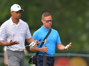 Tiger Woods talks with swing coach Sean Foley on the 10th fairway at Congressional Country Club during the practice round of the 2014 Quicken Loans National.. (Tommy Gilligan/USA TODAY Sports)