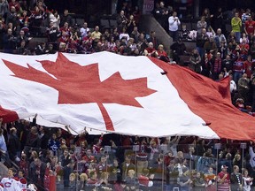 A giant Canadian flag was passed around the crowd during the national anthem prior to a game between the Ottawa Senators and Montreal Canadiens at Scotiabank Place in this January 30, 2010 file photo. (ERROL MCGIHON/QMI Agency)