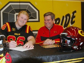Central Elgin Collegiate Institute football star Jessy Kocins, left, signs his letter of intent to play for the University of Guelph Tuesday in the Central Elgin gymnasium. Guelph head coach Stu Lang, right, and defensive coordinator Kevin MacNeill were on hand for the signing.  (Ben Forrest, Times-Journal)