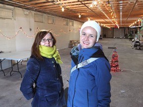 Memorial Centre Farmers' Market marketing and recruitment manager Jolene Simko, left, and operations manager Emma Barken bundle up on Tuesday as they stand inside the E.E. Bennett barn in Kingston, the new home of the market for the next three Sundays in December. The barn will be heated on market days. (Michael Lea/The Whig-Standard)