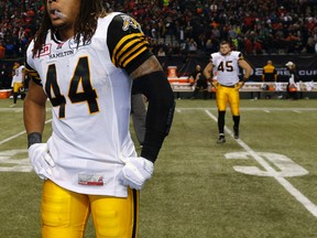 Dejected Hamilton Tiger-Cats Taylor Reed and Arnaud Gascon-Nadon walk off the field after losing 102nd Canadian Football League Grey Cup to the Calgary Stampeders 20-16 in Vancouver on Nov. 30, 2104. (Al Charest/Calgary Sun/QMI Agency)