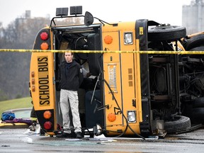 A man stands in front of one of two buses involved in accident in Knoxville, Tennessee, December 2, 2014. Two school buses serving Chilhowee Intermediate School and Sunnyview Primary School crashed on Asheville Highway, killing two children and one adult.  REUTERS/Michael Patrick/Knoxville News Sentinel/TNS