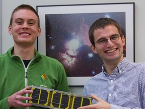 University of Alberta science alumnus Collin Cupido, left, and engineering student Charles Nokes, project lead, hold a life-size model of the satellite Ex-Alta 1, which they hope will help them gather data on the Northern Lights, solar flares and other space weather phenomena. (PHOTO SUPPLIED)