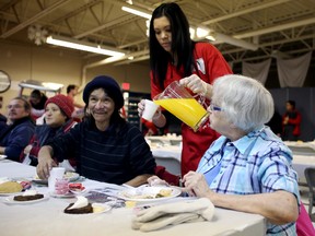 Salvation Army volunteer Linnea Musselman, 23, pours orange juice for William Boudreau, 59, left, and Gladys Proskiw, 82, right, at the annual community Christmas dinner at the Salvation Army’s Community & Family Services (CFS) building, 9620 101A Ave., on Tuesday.