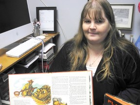 Stardust Book Lounge owner Anne Marie Caron holds up a first edition of "Once Long Ago" by Roger Lancelyn Green. The bookseller is hosting a silent auction this month featuring rare books to fundraise for Sarnia Artwalk. Bidding for "Once Long Ago" starts at $300. (BARBARA SIMPSON, The Observer)